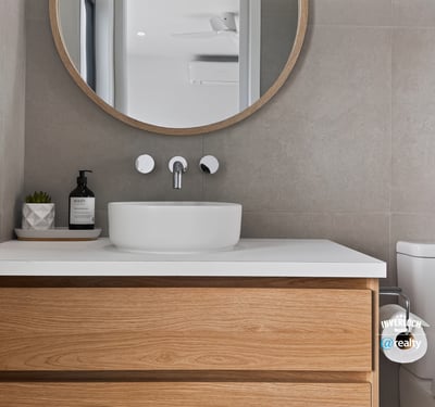 Modern bathroom featuring a sleek sink, circular mirror, and warm wooden cabinetry for practical elegance.