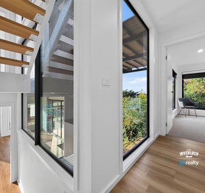 Bright, open hallways lead to inviting spaces with lush outdoor views and modern finishes.