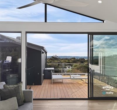 Bright and airy living space opens to a spacious deck, offering stunning views of the landscape.
