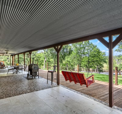 Spacious covered porch offers panoramic nature views, perfect for outdoor gatherings and relaxation.