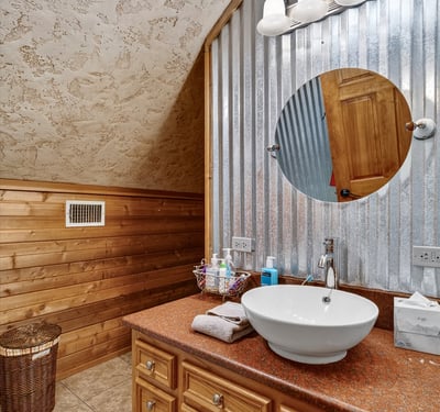 This unique bathroom features rustic wood accents and modern fixtures, creating a warm and inviting atmosphere.