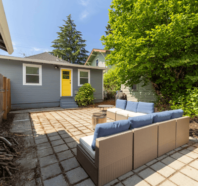 Bright outdoor space featuring a cozy seating area, surrounded by lush greenery and a welcoming atmosphere.