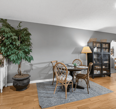 Bright and inviting living space featuring a cozy dining area and rich hardwood flooring throughout.