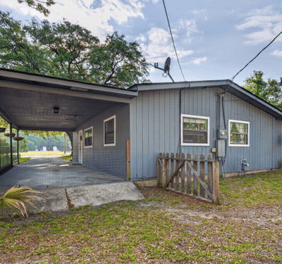 This versatile property features a spacious covered carport and a welcoming outdoor space for gatherings.
