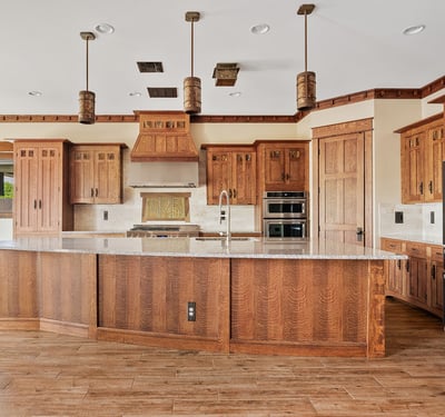 Rich wood cabinetry, detailed millwork, built-in appliances, and a striking range hood define this custom kitchen, delivering both visual appeal and everyday practicality in this Phoenix home.