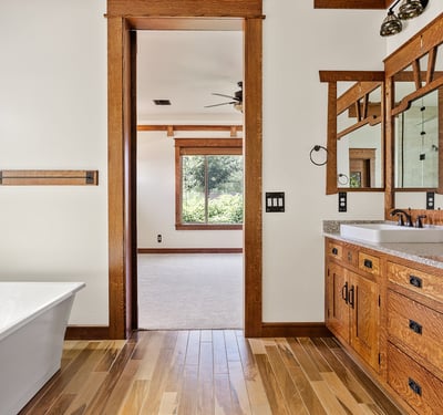 Spa inspired bathroom featuring a dual vanity, natural wood cabinetry, quartz counters, and modern fixtures. A luxurious and functional primary bath in this Phoenix residence.