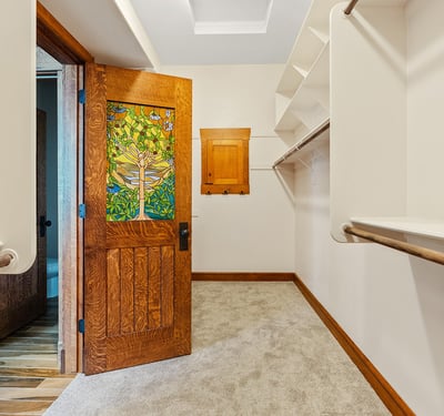 Walk-in closet offering ample shelving, hanging space, and distinctive wood detailing. Designed to combine organization, style, and character within the primary suite.