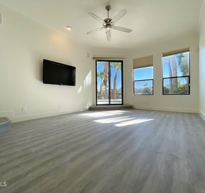 Contemporary living area with sleek flooring, recessed lighting, and sliding glass doors leading to the patio and pool area ideal for indoor-outdoor living.