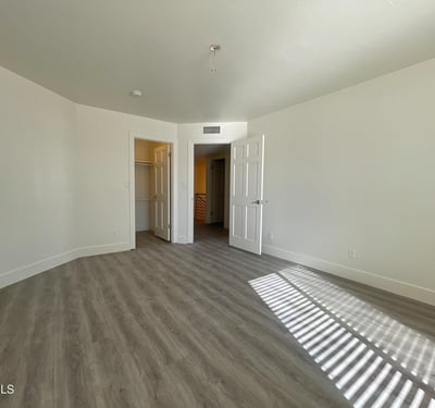 Fresh, airy bedroom with rich flooring and closet space. Large windows bring in Scottsdale s natural light.