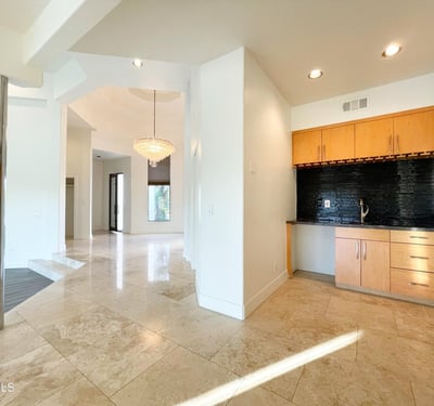 Built-in bar with sleek finishes and granite surfaces adds both convenience and luxury to the open living area.