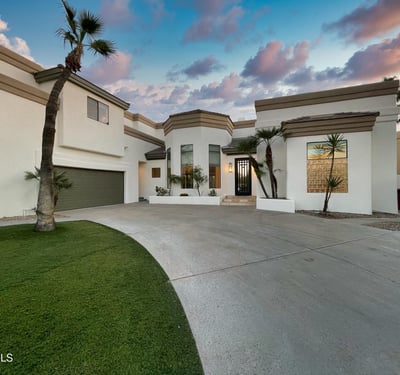 Evening glow illuminates the home s bold lines and architectural beauty, framed by soft desert light.