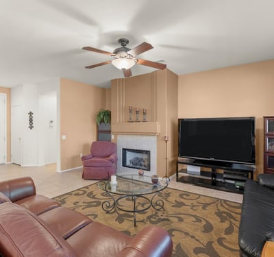 Cozy up by the gas fireplace in this elegant living area. Large windows and earthy tones create a comfortable setting for relaxing evenings at home.