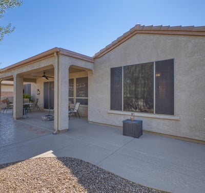 An extended patio designed for entertaining with ceiling fan, lighting, and plenty of space for seating under the Arizona sky.