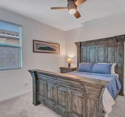 Highlighted by rich wood furniture and soft natural light, this stylish guest bedroom offers comfort and charm throughout this Litchfield Park home.