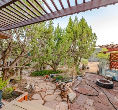 This rustic outdoor zone features stone flooring, raised garden areas, and a pergola for shade. A relaxing space to enjoy Hackberry s natural quiet.