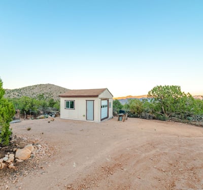 A functional workshop sits against a backdrop of scenic mountains, providing useful storage or project space with unmatched Hackberry views.
