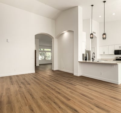 Expansive Scottsdale interior showing the open connection between living room and kitchen. High ceilings, recessed lighting, and updated finishes enhance the home's modern open floor plan.