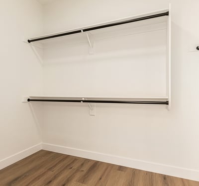 Generous walk-in closet with ample hanging rods and shelving for clothing storage. This Scottsdale closet provides convenient organization within the primary suite.