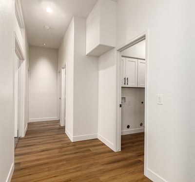 Bright hallway with updated flooring and neutral finishes connecting the living areas and bedrooms of this Scottsdale home. High ceilings and clean architectural lines enhance the spacious feel of the remodeled interior.