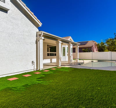 Large Scottsdale backyard combining a manicured lawn with a private pool and covered patio. The outdoor space offers room for entertaining, recreation, and peaceful relaxation.