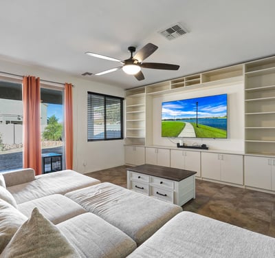 Open great room with built-in cabinetry, tile floors, and natural light, connecting indoor comfort with outdoor access.