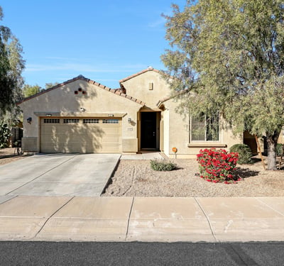 Clean front elevation with attached garage and desert landscaping, highlighting the home s single-level layout and easy-care design.
