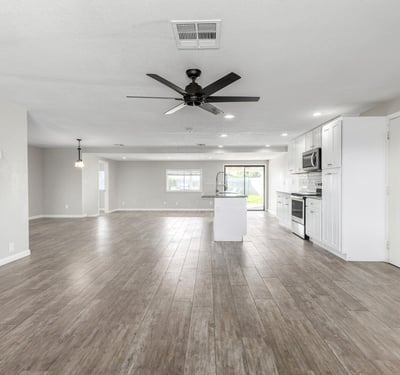 Open-concept great room with recessed lighting, ceiling fan, and wood-look tile flooring offering a bright, airy layout that connects directly to the upgraded kitchen in Phoenix.
