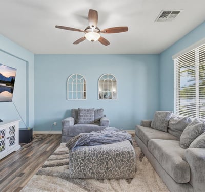 Comfortable living space with wide windows, neutral finishes, and modern flooring creating a bright and relaxing atmosphere inside this Queen Creek home.