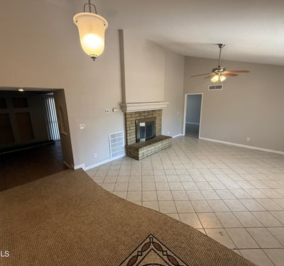 Bright Glendale living room with classic fireplace, tile flooring, and spacious layout. The room offers plenty of space for gatherings and everyday living.