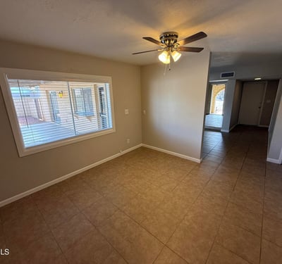 Bedroom with sliding doors opening directly to the backyard patio and pool area. Natural light and tile flooring enhance the bright feel of the room.