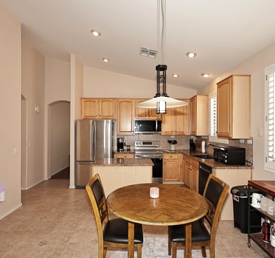 Open-concept kitchen and dining space with granite counters and plantation shutters. This Phoenix home is designed for easy entertaining and daily living.