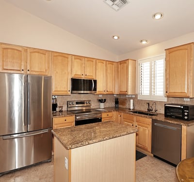 Kitchen with abundant cabinetry, granite surfaces, and stainless steel appliances. This Phoenix property offers both style and storage for modern living.