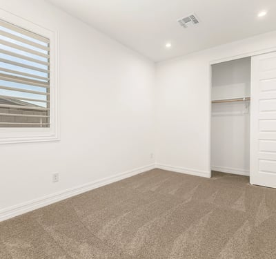 Well-appointed bedroom with closet storage, neutral palette, and plush carpeting, ideal for guests or everyday use.