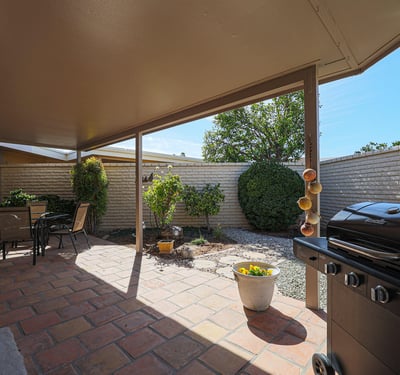 Covered patio with paver flooring and outdoor seating area, ideal for enjoying Arizona-style indoor-outdoor living.
