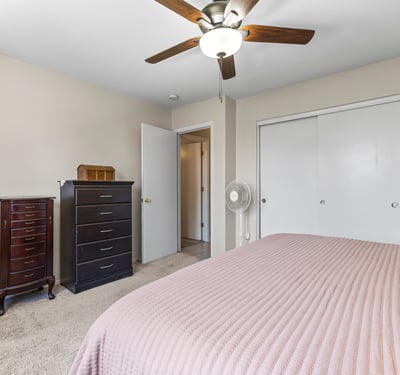 Bright primary suite with dual closets, ceiling fan, and convenient access to the bathroom. A functional and inviting layout.