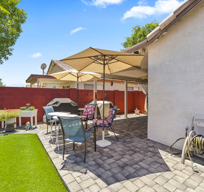 Inviting backyard with artificial turf, patio seating, and landscaped accents. Designed for entertaining and low-maintenance living.