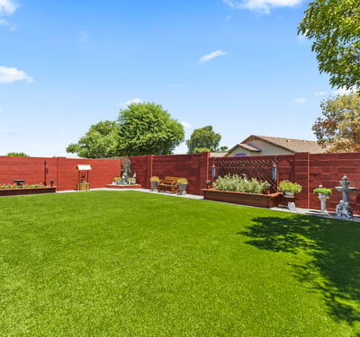 Peaceful backyard featuring mature trees, turf lawn, and privacy fencing. A relaxing outdoor environment with ample space.
