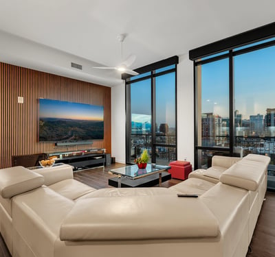 Open living area filled with natural light, featuring floor-to-ceiling windows and panoramic Phoenix views, perfect for modern indoor-outdoor living.