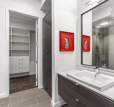 Well-designed bathroom with modern vanity, glass shower, and convenient access to a large closet, offering both style and practicality in Phoenix.