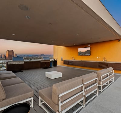 Stylish rooftop entertainment area featuring built-in grills, seating, and open-air design, ideal for hosting in Phoenix.