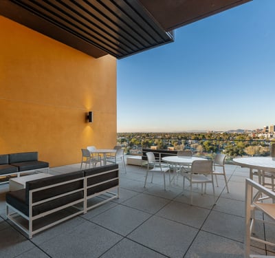 Covered community space with ample seating and dining options, perfect for relaxing or hosting while enjoying Phoenix views.