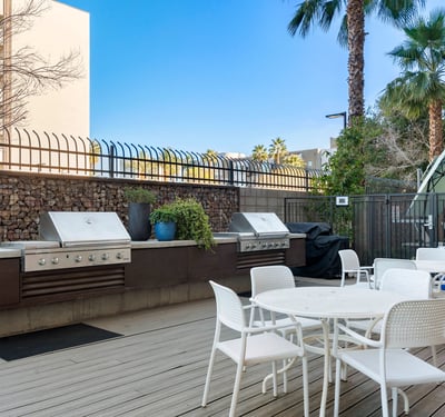 Outdoor BBQ area with multiple grills, seating, and modern finishes, creating a perfect gathering space in Phoenix.