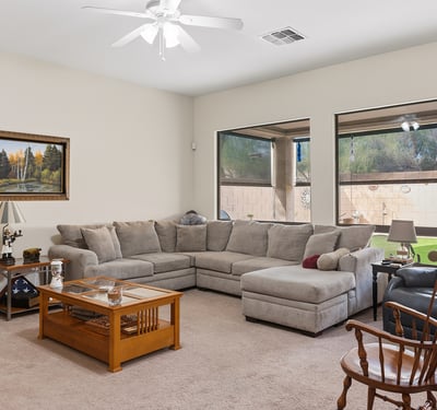 Bright living room with large windows, open layout, and comfortable design, ideal for both entertaining and relaxing in this Phoenix property.