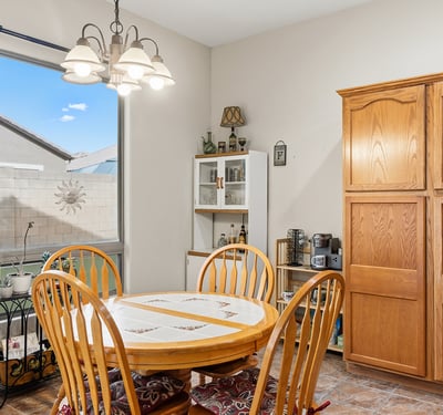 Cozy dining space with large window and backyard views, offering a bright and welcoming setting for meals in this Phoenix home.