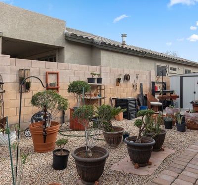 Generous side yard featuring artificial turf and desert landscaping, perfect for outdoor activities in this Phoenix home.
