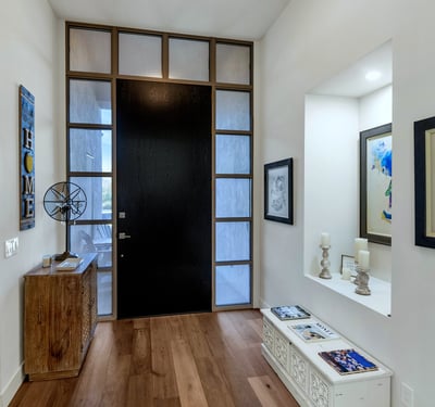 Modern entry with tall ceilings, wood flooring, and striking front door design, creating a welcoming arrival experience in Phoenix.