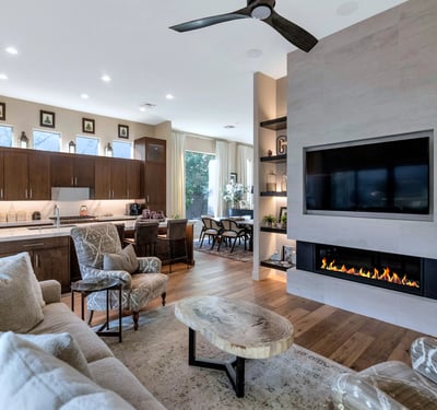 Open living area featuring a sleek fireplace, built-in shelving, and connection to the kitchen for easy entertaining in Phoenix.