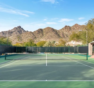 Community tennis court set against scenic mountain views, offering recreational amenities in this Phoenix neighborhood.