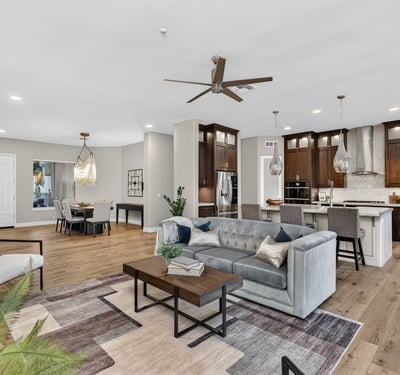 Expansive open floor plan connecting living, dining, and kitchen areas with wood flooring and modern design, ideal for Scottsdale entertaining.