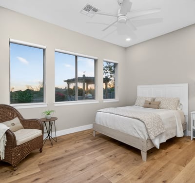 Scottsdale bedroom with multiple windows, wood flooring, and abundant natural light, creating an open and airy feel.